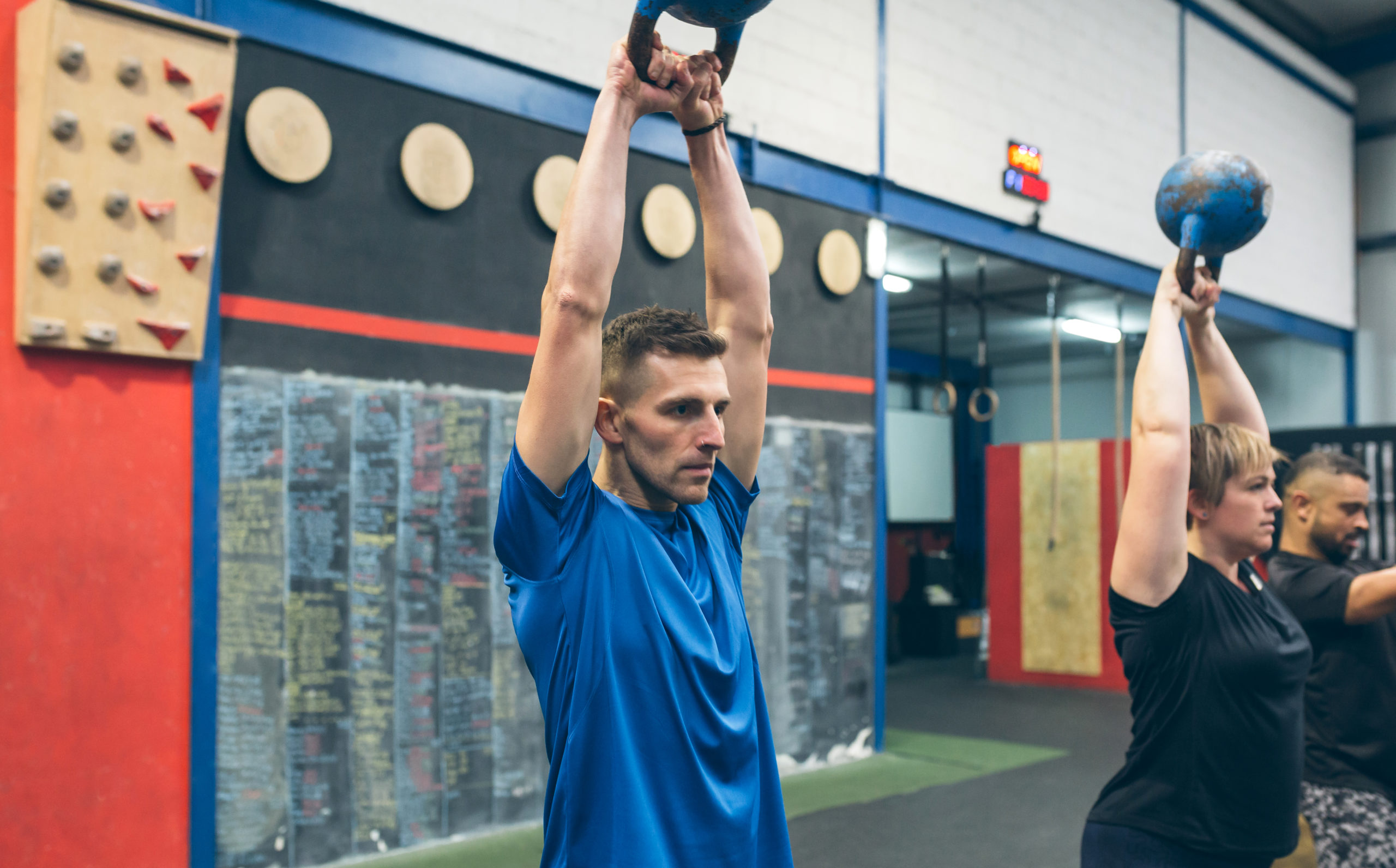 Sportsman exercising with kettlebell with his partners sportsman exercising at a YM